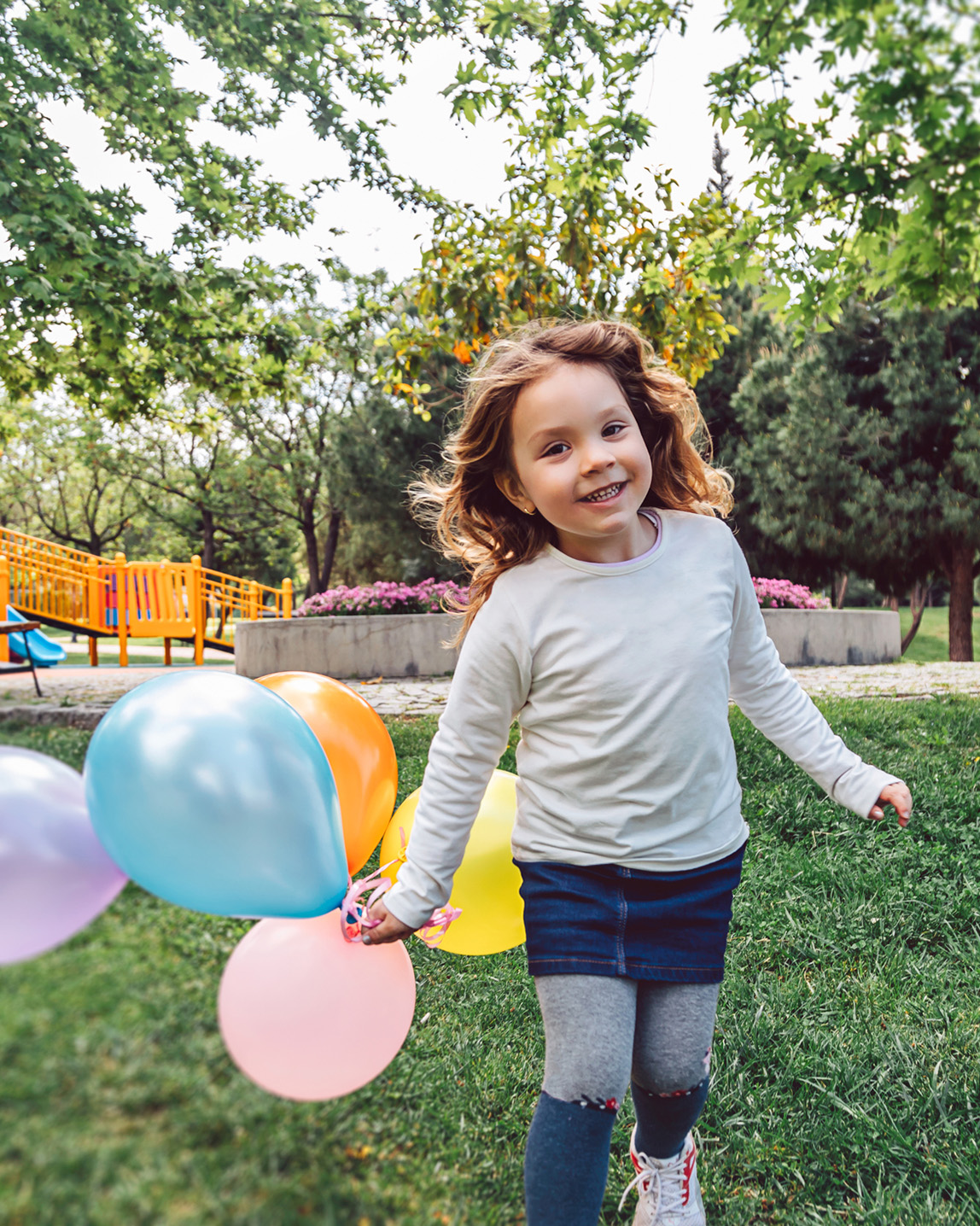 Happy Child Running with Balloons.